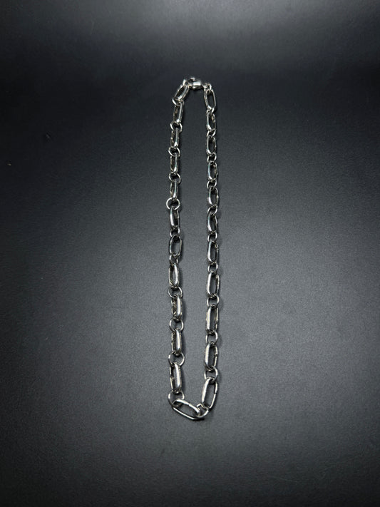 Silver chain necklace on a dark gray background