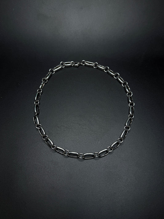 Black chain necklace on a dark gray background